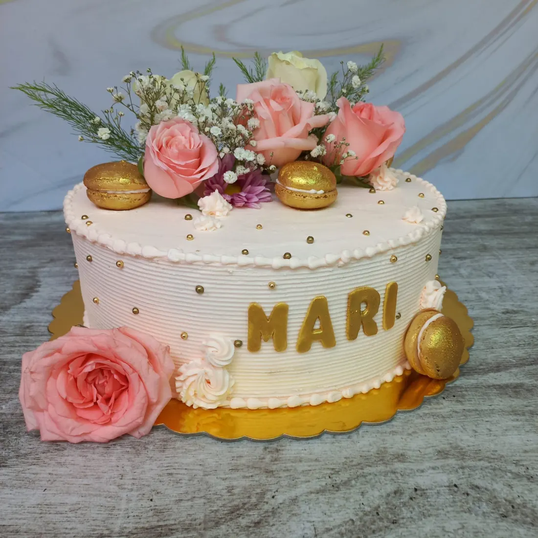 Torta con flores naturales y detalles dorados